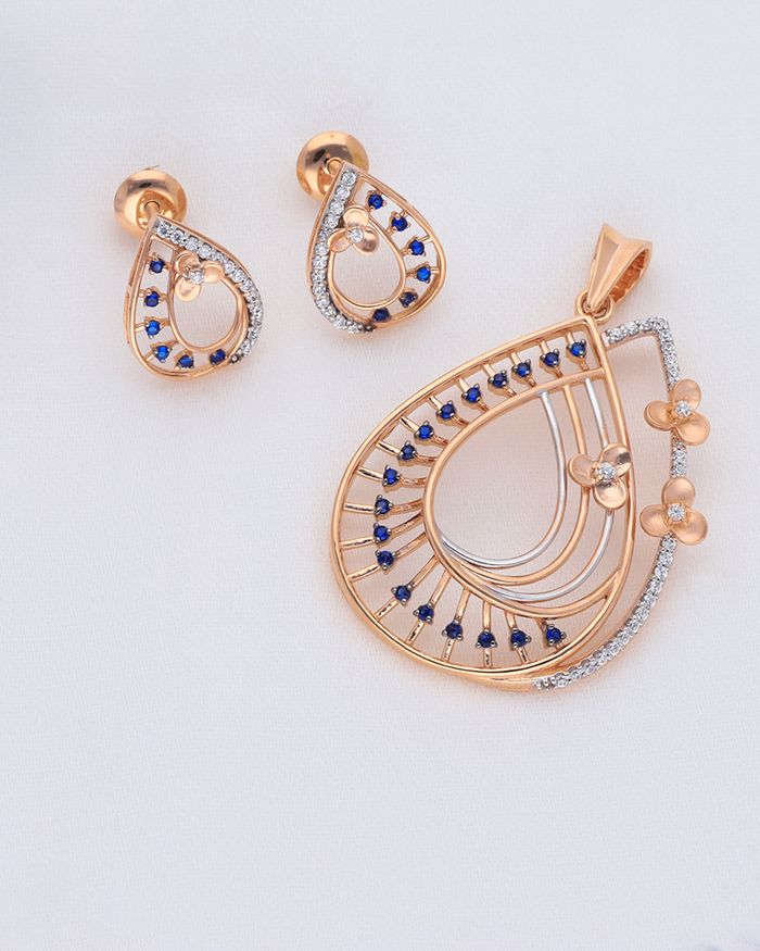 Close-up of a gold pendant and earrings with blue gemstones