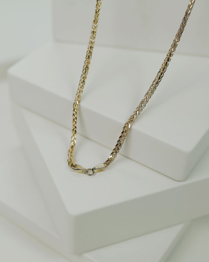 Ornate gold necklaces displayed on a jewellery stand